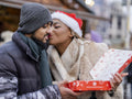 Young couple holding box at Christmas market