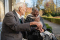 Smiling senior people relaxing on bench in park
