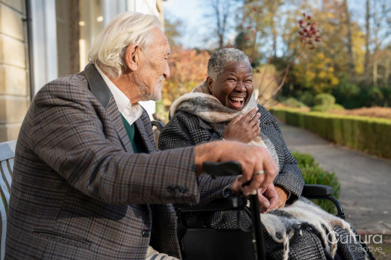 Smiling senior people relaxing on bench in park
