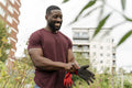 Smiling man putting on gloves in urban vegetable garden