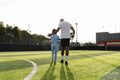 Rear view of coach and girl on soccer field