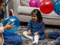 Siblings playing with balloon at home