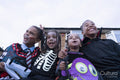 Smiling children in Halloween costumes sitting in front of house