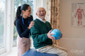Smiling senior man exercising with physical therapist