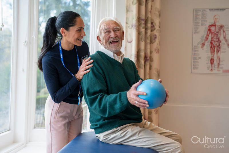 Smiling senior man exercising with physical therapist