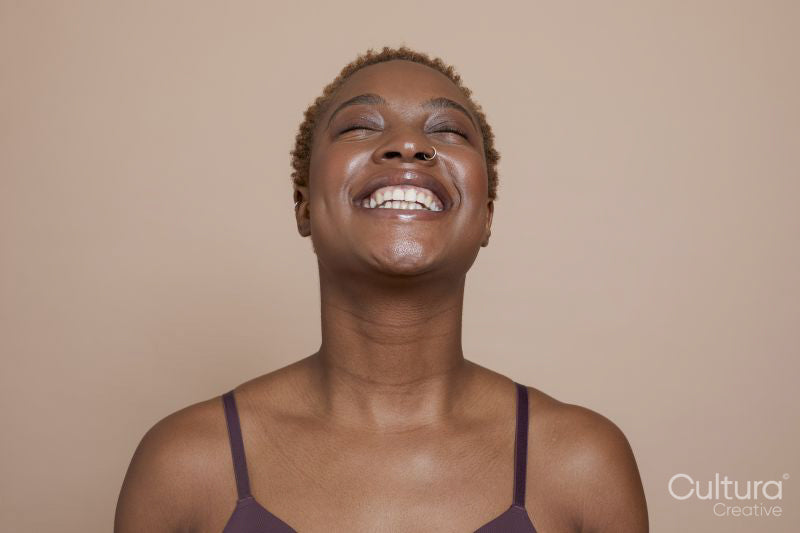 Studio portrait of smiling woman with eyes closed