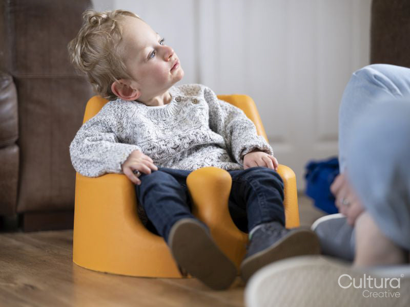 Boy in baby seat looking at mother