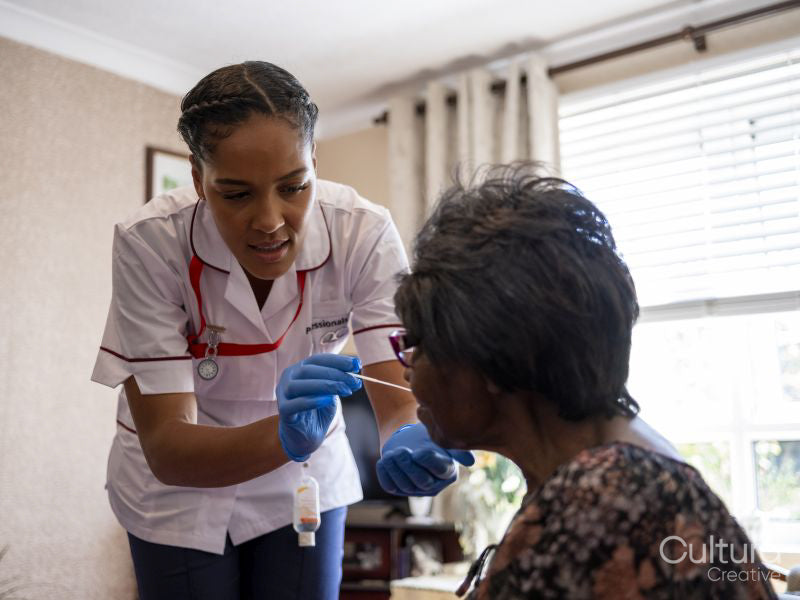 Nurse taking care of elderly woman, taking nasal sample for testing
