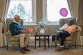 Smiling senior man and woman playing with balloon in nursing home