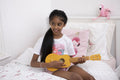 Girl playing ukulele on bed