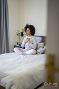 Young woman meditating on bed