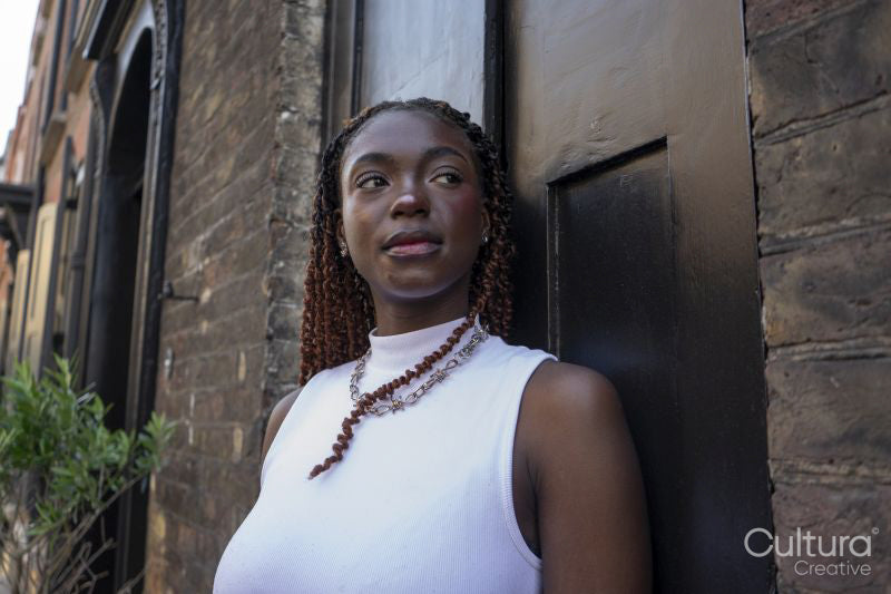 Woman with brown hair wearing white top