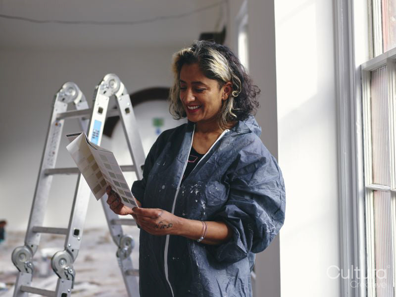 Woman looking at color swatch in loft apartment