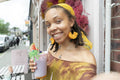 Portrait of young woman drinking smoothie in city