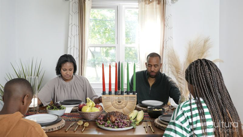 Family with children praying before Kwanzaa meal