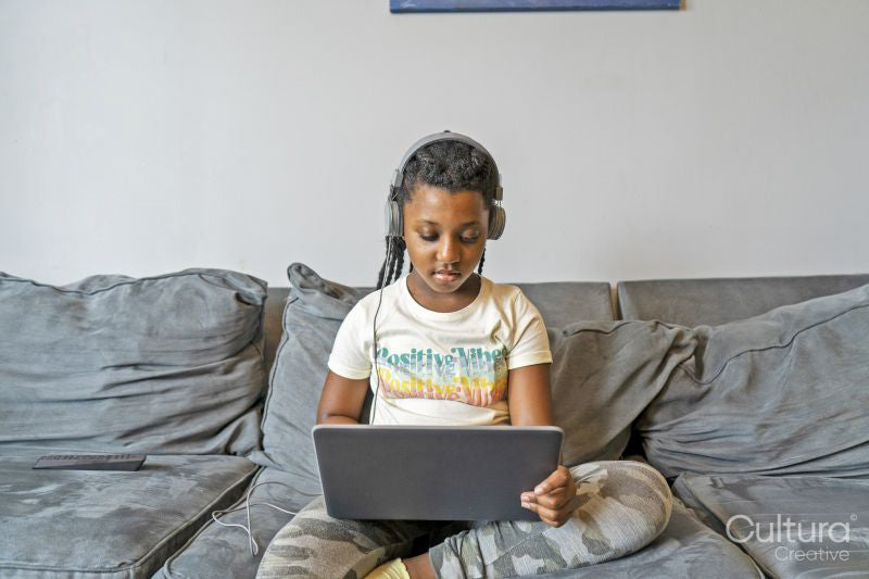 Girl using laptop on sofa