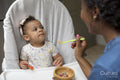 Mother feeding baby daughter