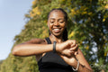 Smiling young woman checking time after jogging