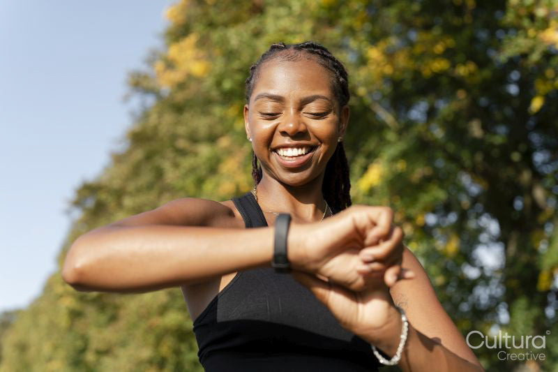 Smiling young woman checking time after jogging