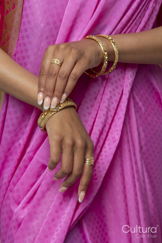 Mid section of woman wearing sari and gold jewelry