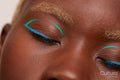 Woman with blue and green make up, eyes closed