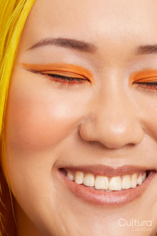Portrait of smiling woman wearing orange make up