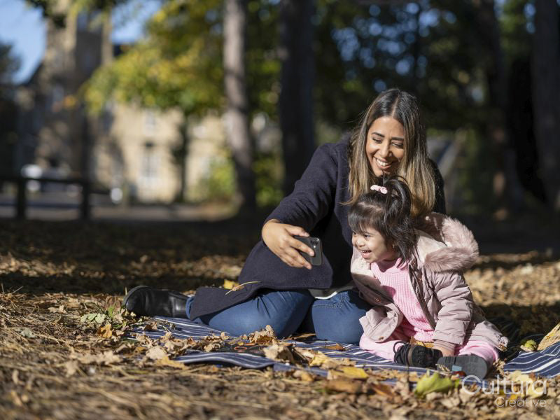Mother and daughter with Down syndrome taking selfie in park