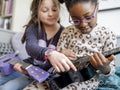 Girl friends playing ukulele at home