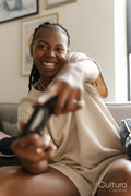 Excited young woman playing video games while sitting on sofa at home