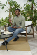 Young man with smartphone sitting in office lounge