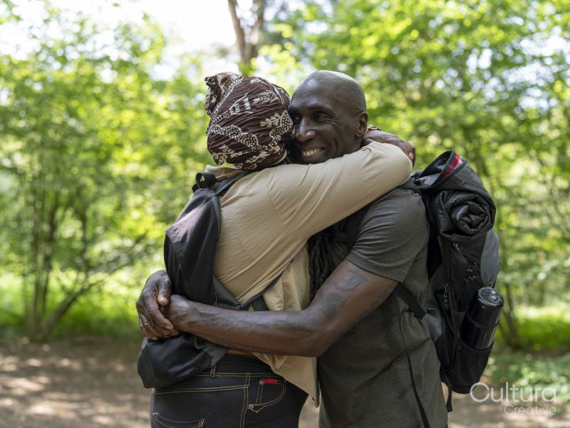 Smiling hiking couple hugging in forest