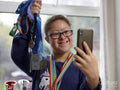 Girl with Down syndrome taking selfie with medals