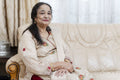 Portrait of senior woman sitting on sofa in living room