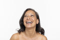 Studio portrait of smiling shirtless woman looking up