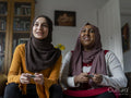 Women playing video game at home