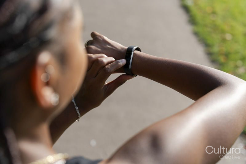 Young woman checking watch after jogging