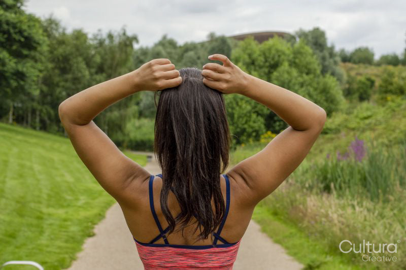 Rear view of woman tying hair before training