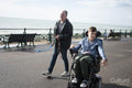 Father and disabled son strolling on promenade