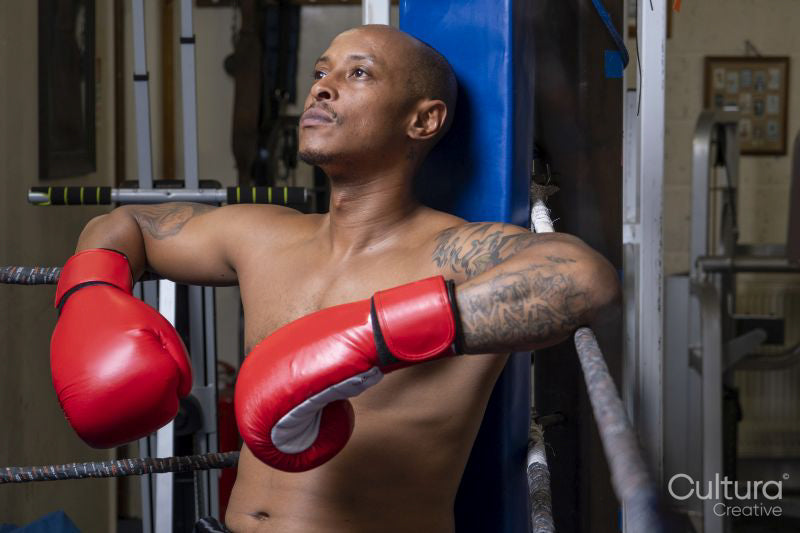 Mature man resting in corner of boxing ring