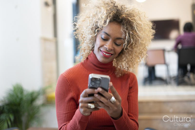 Smiling woman using smart phone in office