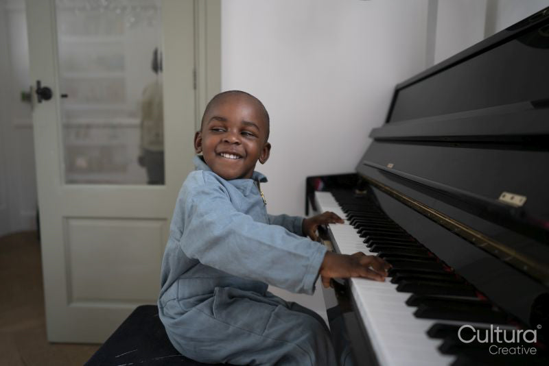 Smiling boy playing piano