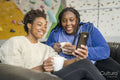 Mother and daughter looking at smart phone after training on climbing wall