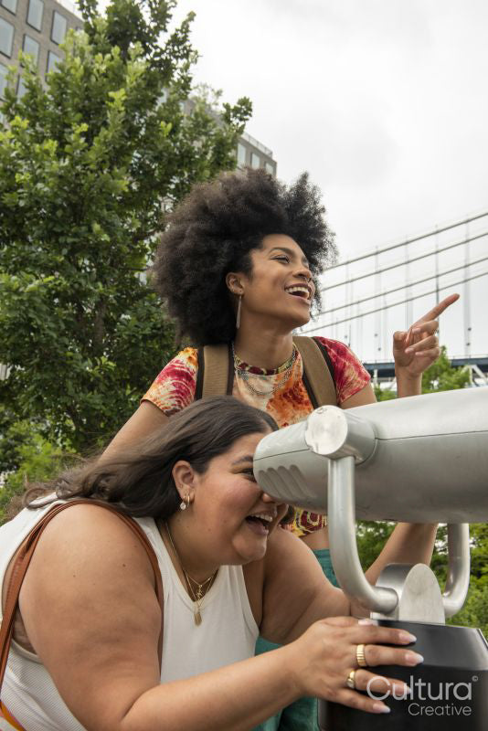 Two women using telescope for sightseeing