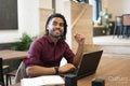 Smiling businessman working on laptop in office