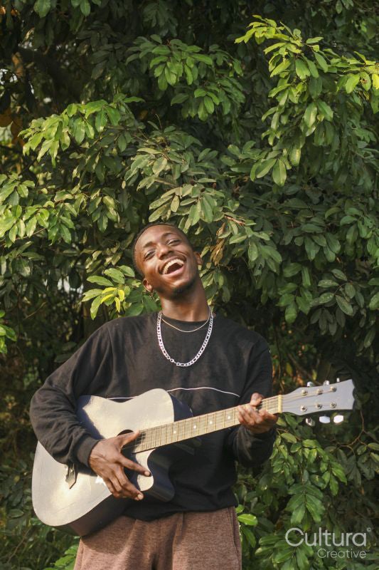 Portrait of young man holding acoustic guitar