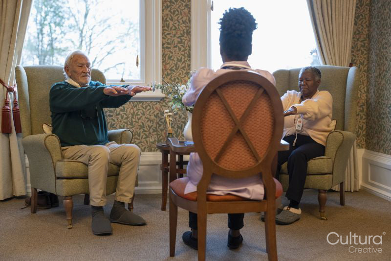 Smiling senior people exercising with nurse in nursing home
