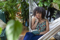 Woman sitting in hammock and reading book