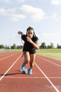 Female athlete sprinting off starting line at stadium