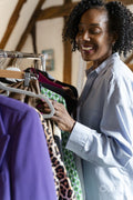 Smiling fashion designer looking at clothes
