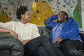 Mother and daughter sitting on sofa in front of climbing wall